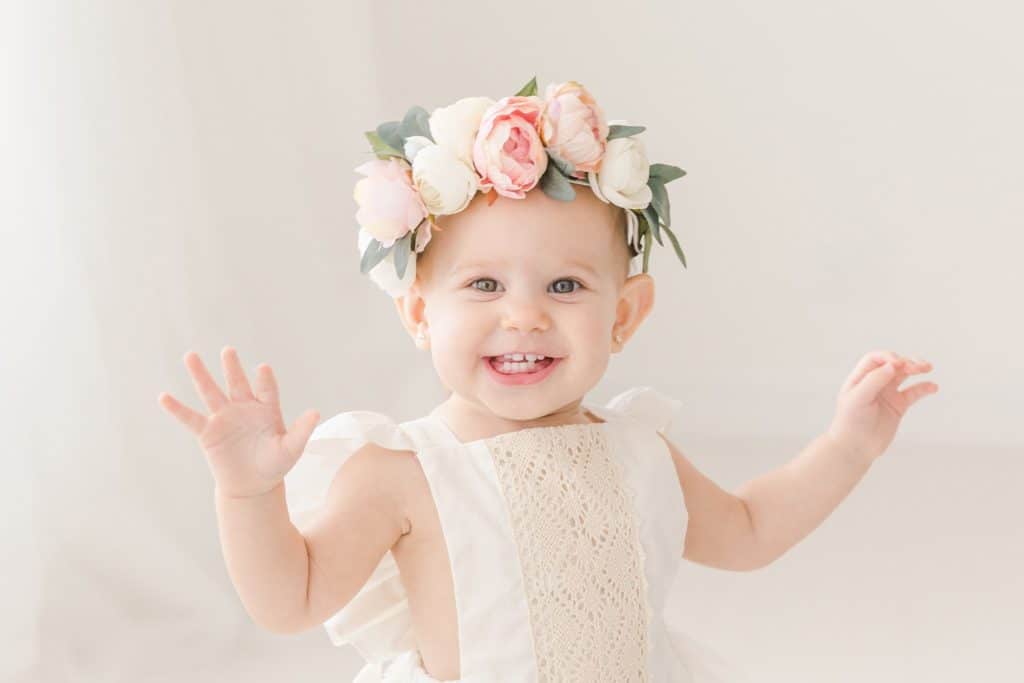 A baby girl wears a flower crown.