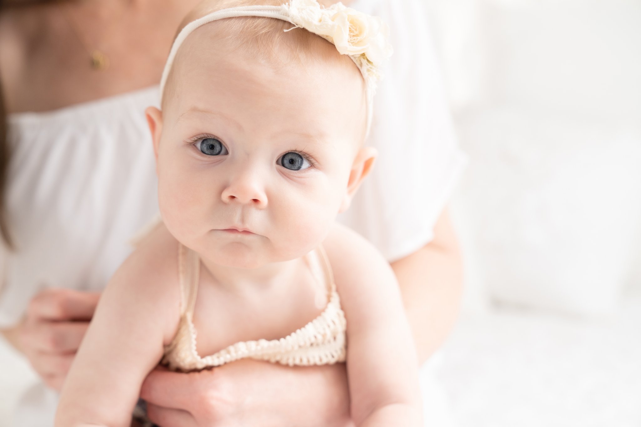 Photos of a baby girl being on her mamas lap in Jupiter Fl photography studio