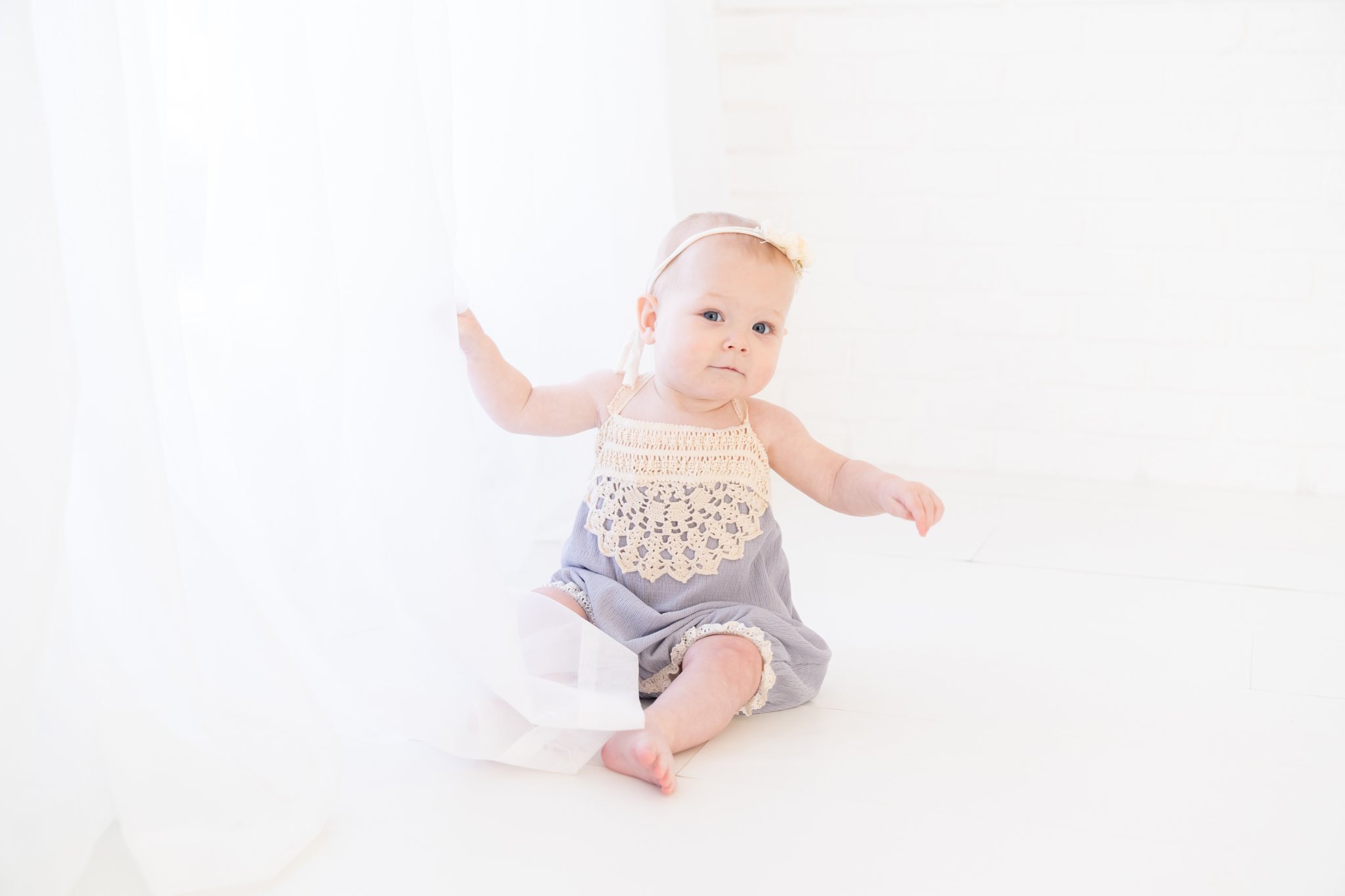 Baby girl being photographed in photography studio.