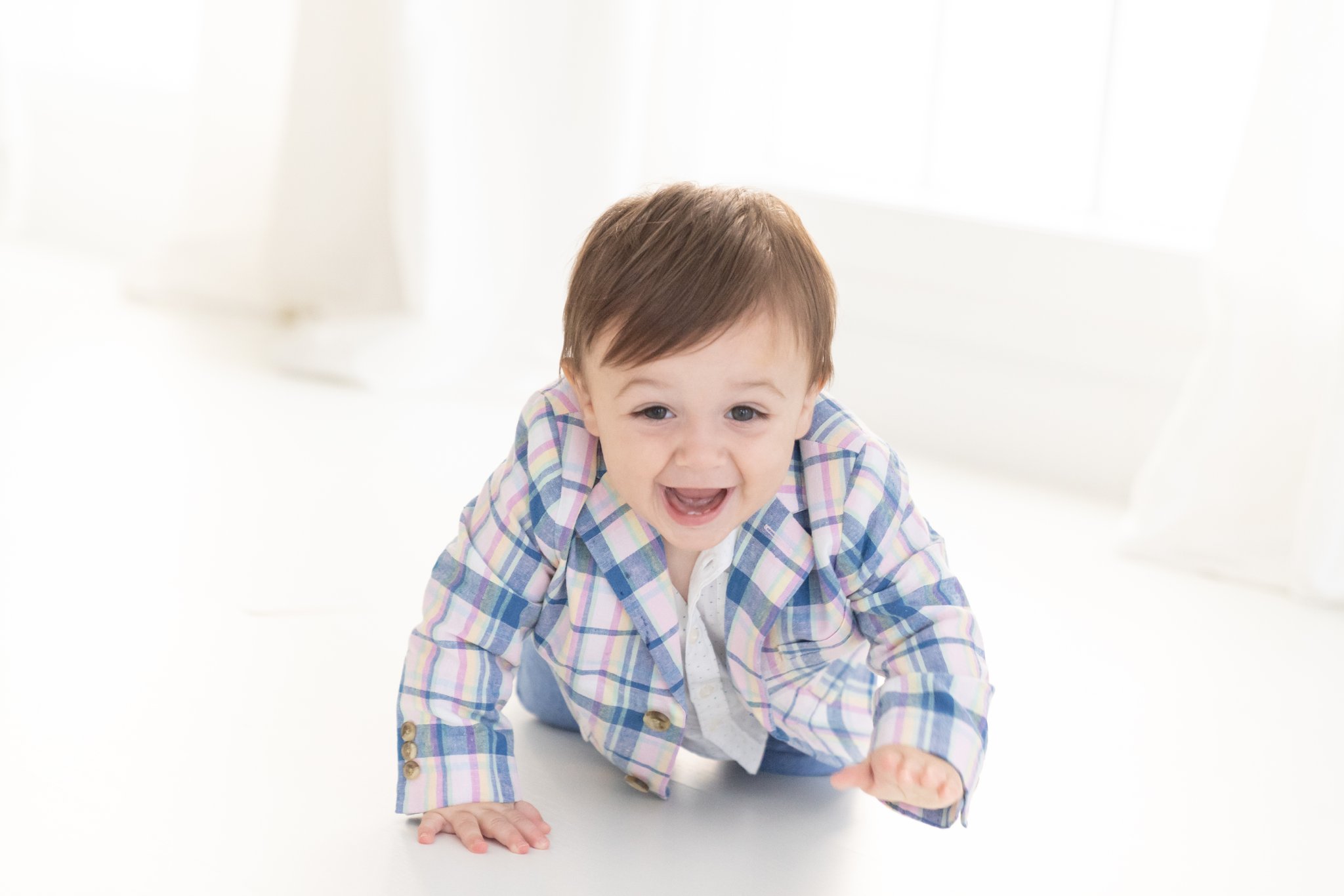 Baby boy wearing cute plaid jacket in jupiter photography studio.