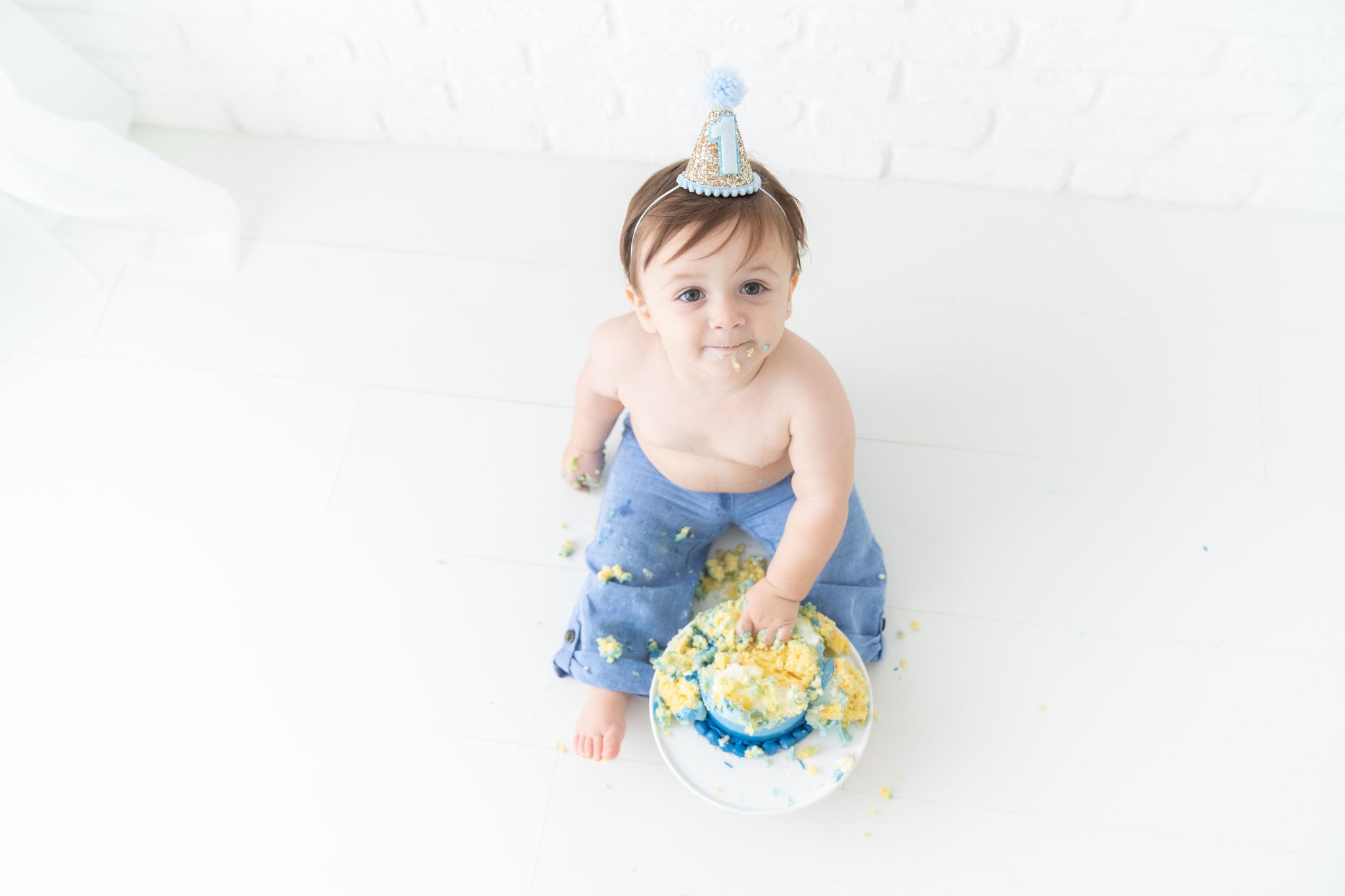 Baby boy with his first birthday cake smash cake. 