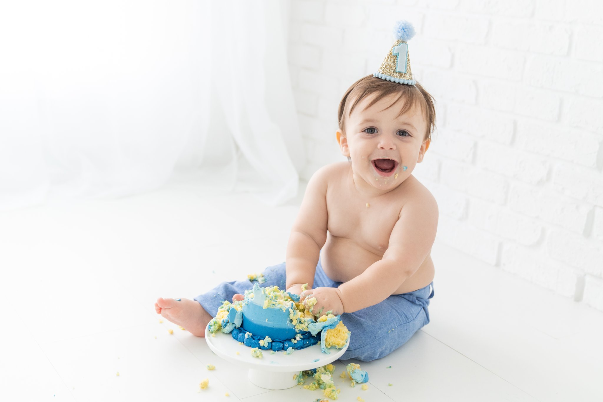 Baby boy with his first birthday cake smash cake. 