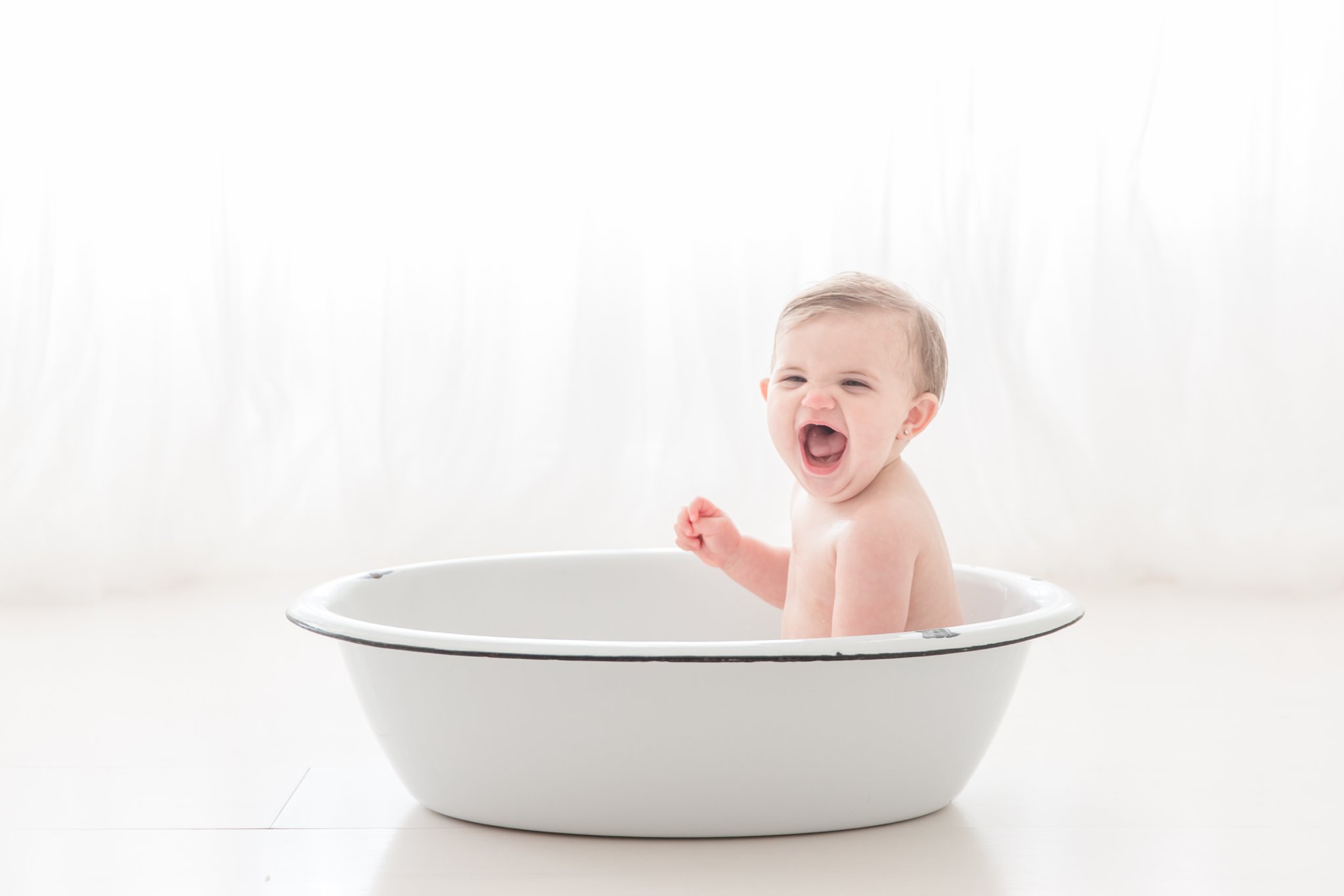 Baby playing in an antique wash basin in jupiter florida photo studio.  
