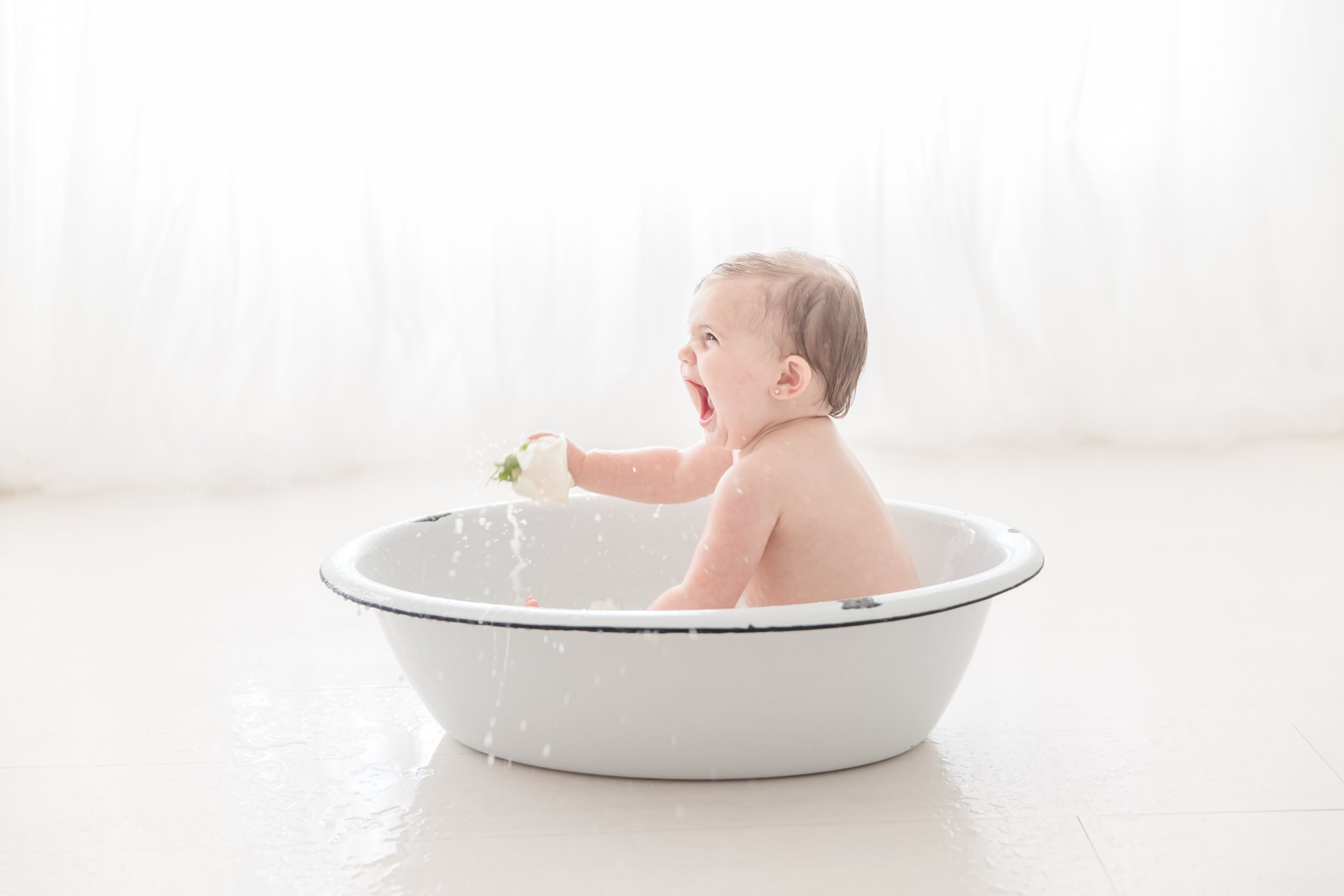 Baby playing in an antique wash basin in jupiter florida photo studio.  