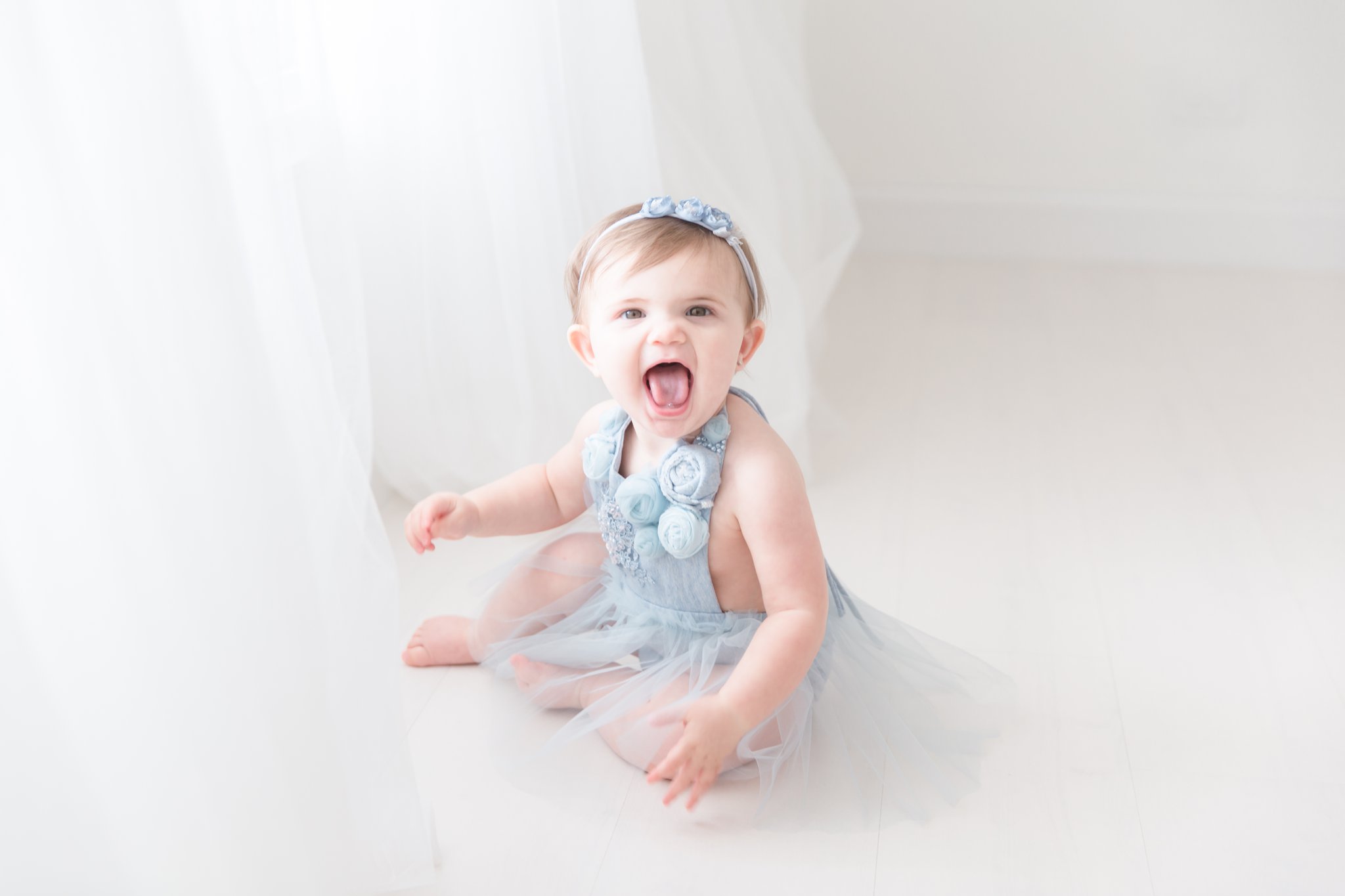 One year old baby having a portraits taken in handmade blue dress.
