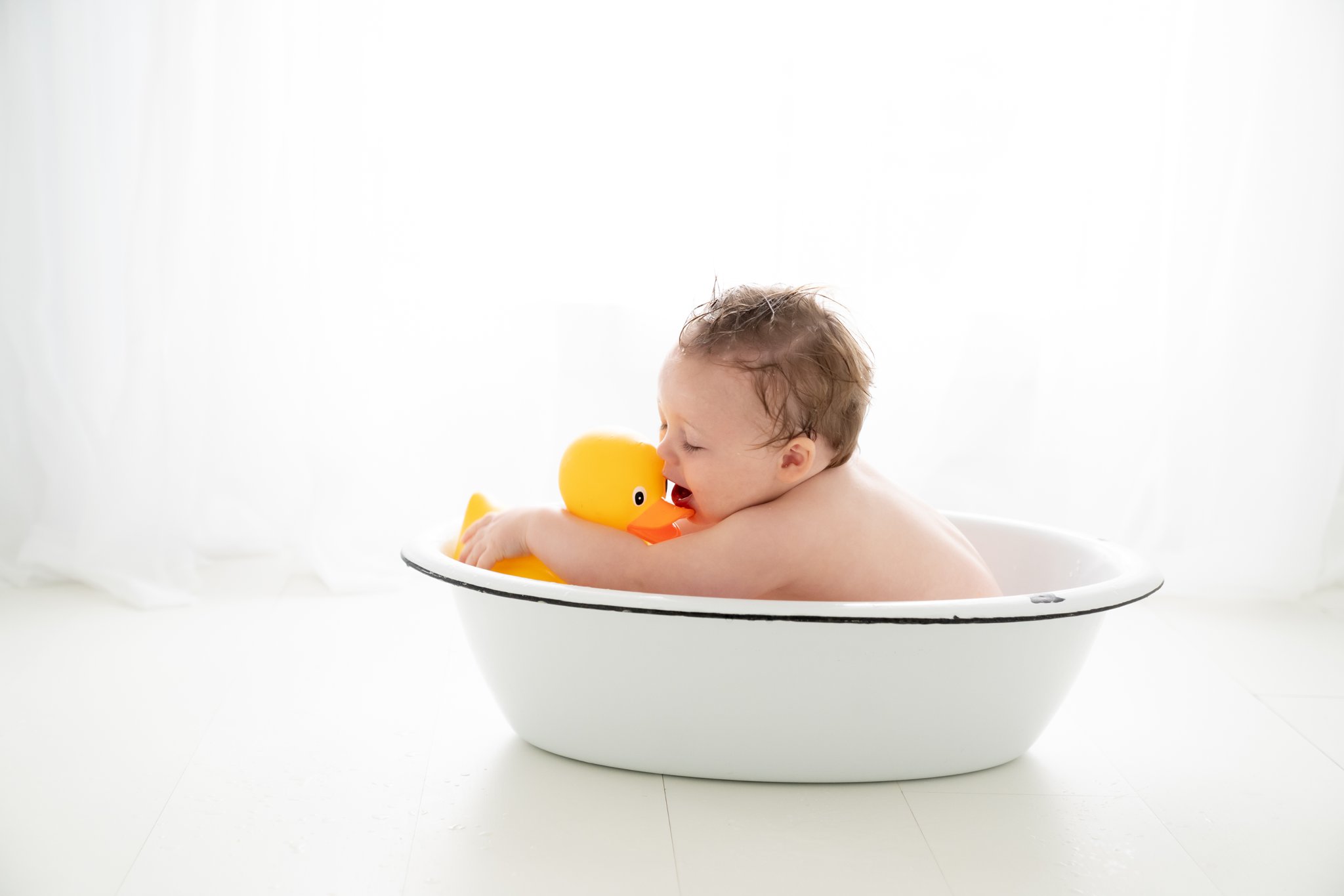 One year old baby in antique tub wash basin in south florida baby photography studio. 