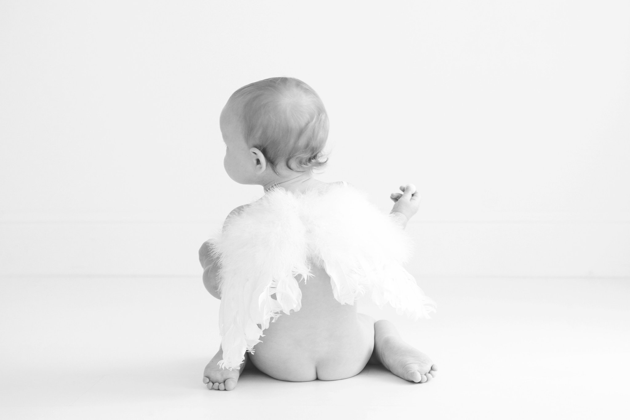 One Year wearing angel wings being photographed in a palm beach photography studio
