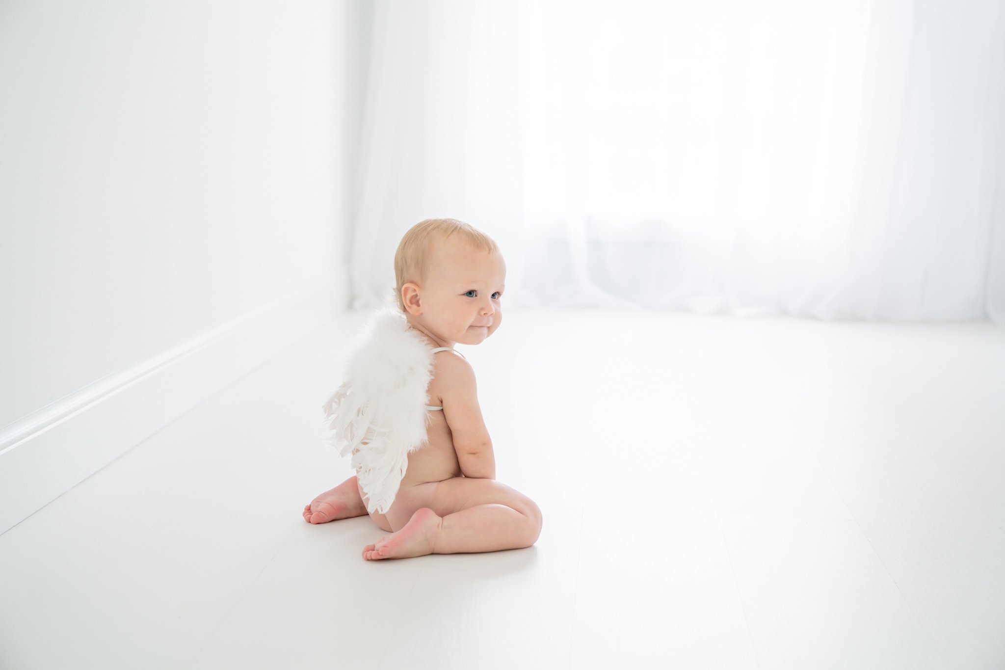 One Year wearing angel wings being photographed in a palm beach photography studio