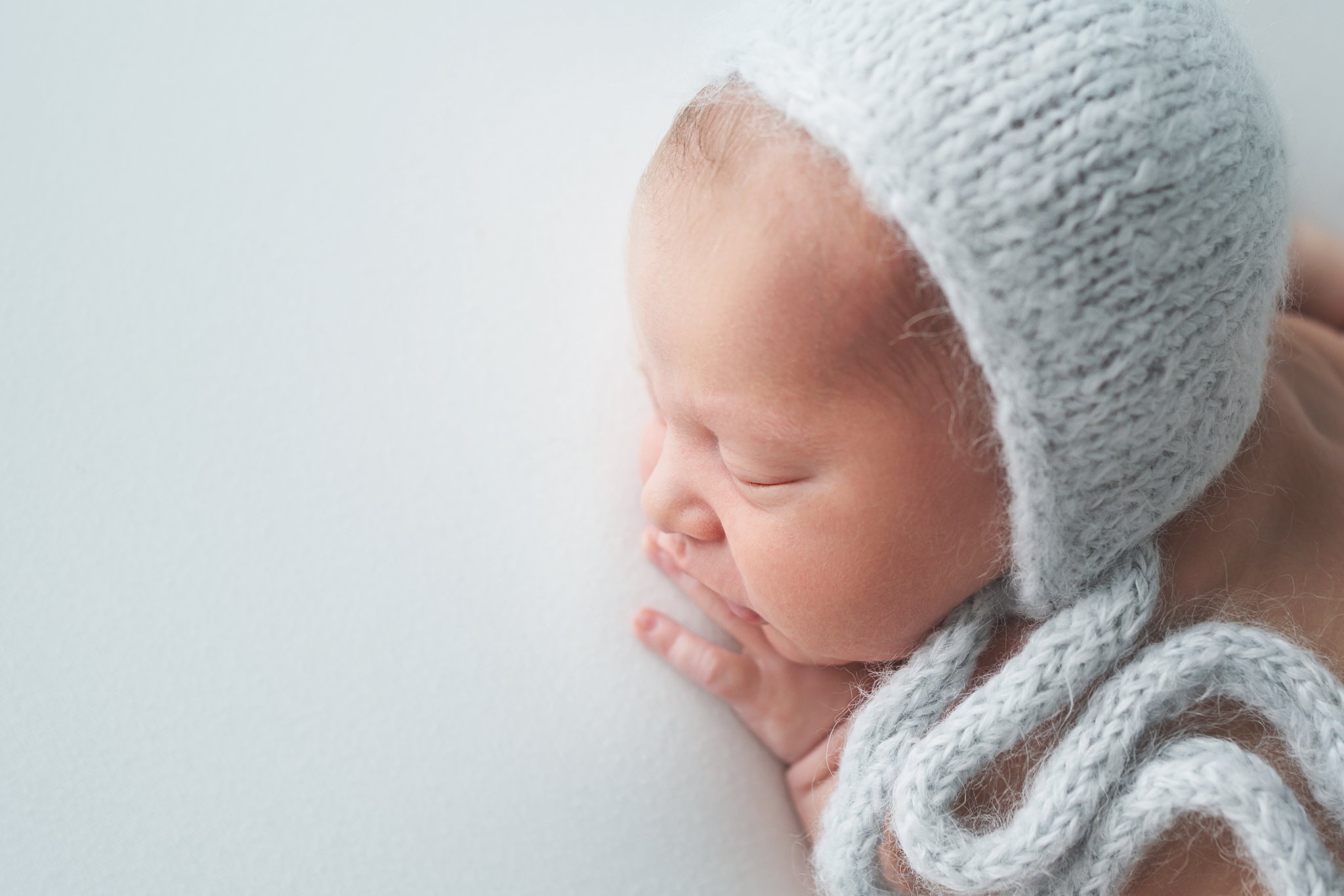10 day old newborn posing on baby blue backdrop in jupiter florida photography studio