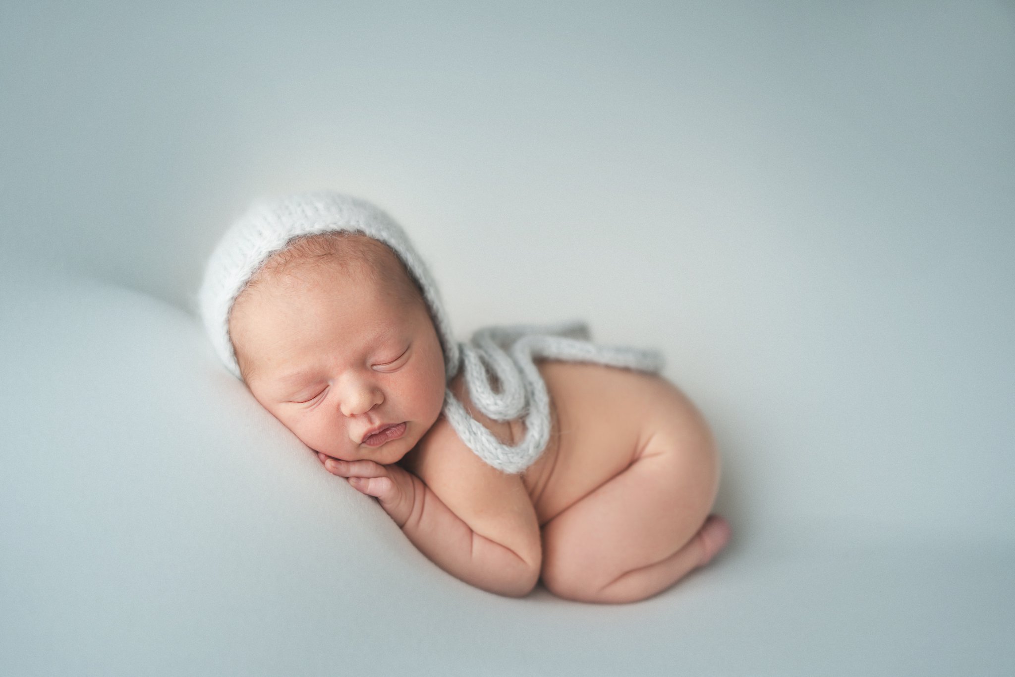 10 day old newborn posing on baby blue backdrop in West Palm Beach Photography studio