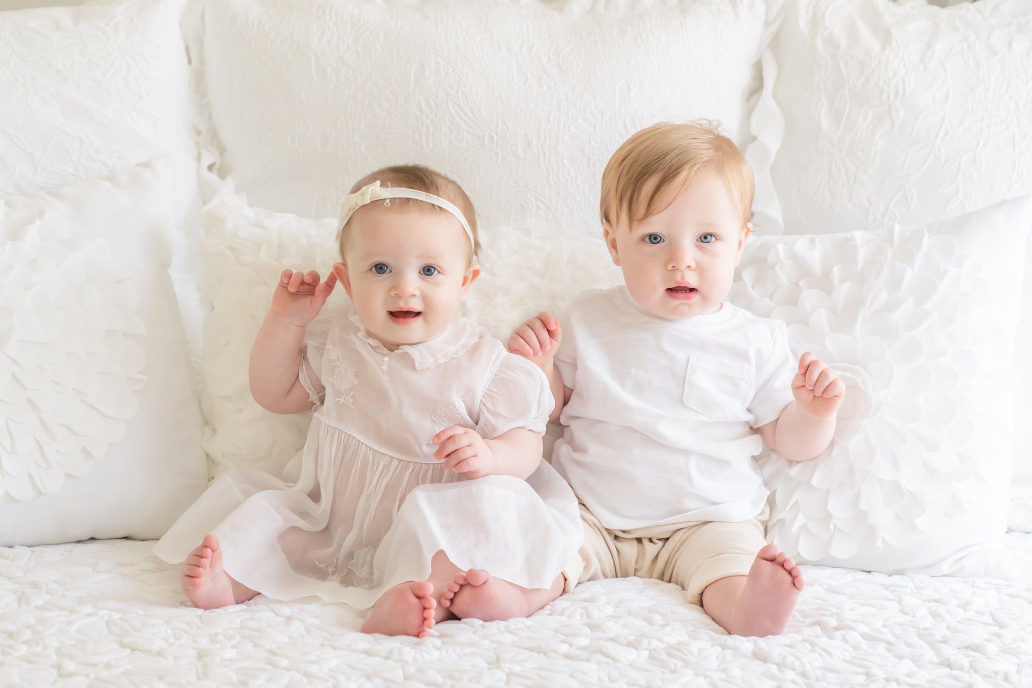 Boy Girl twins on white bed 