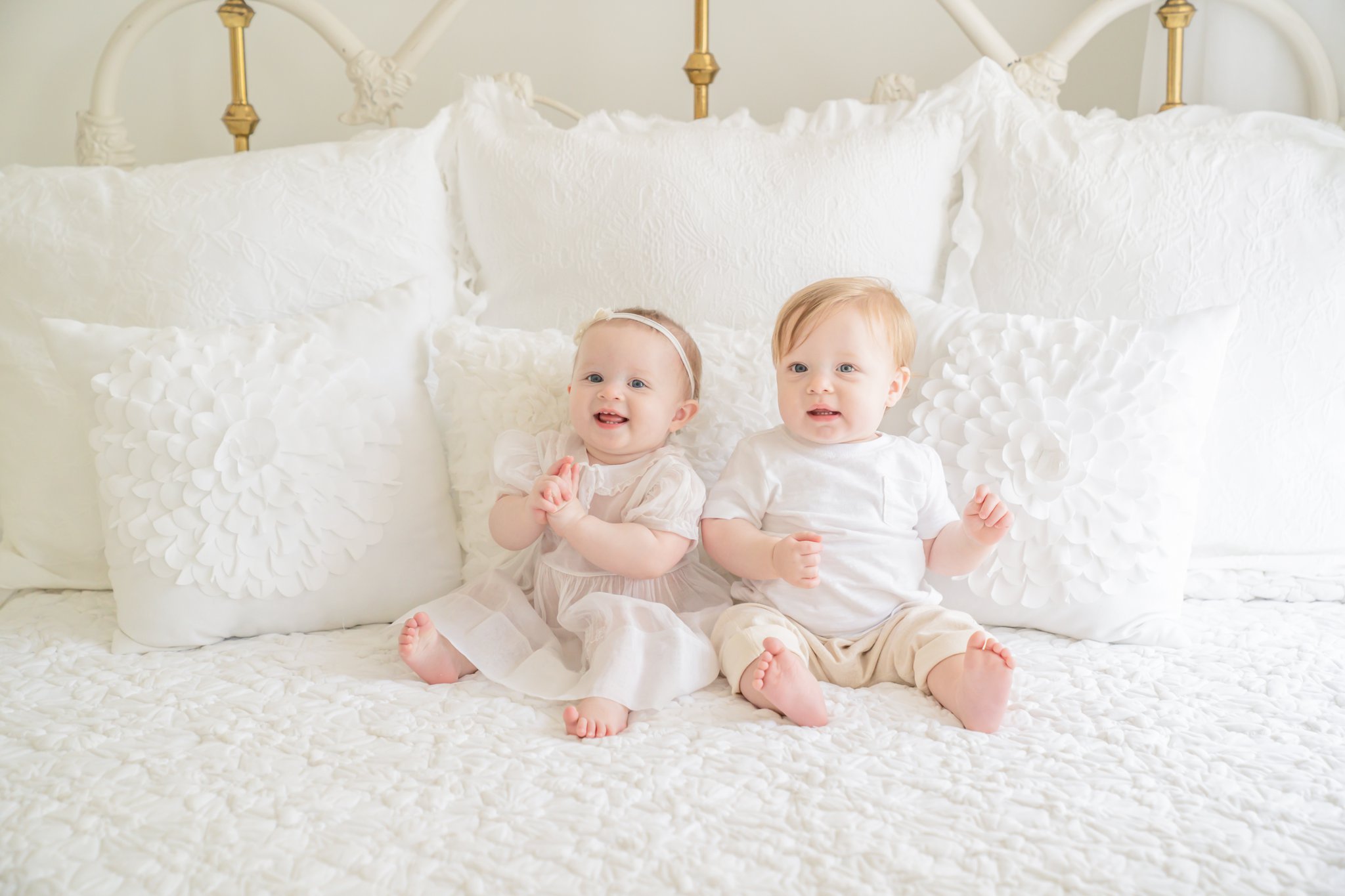 Boy Girl twins on white bed 