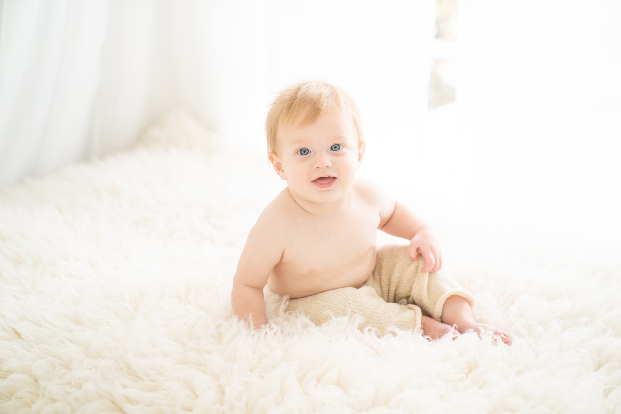 Baby being photographed on white fur rug in Jupiter Fl studio