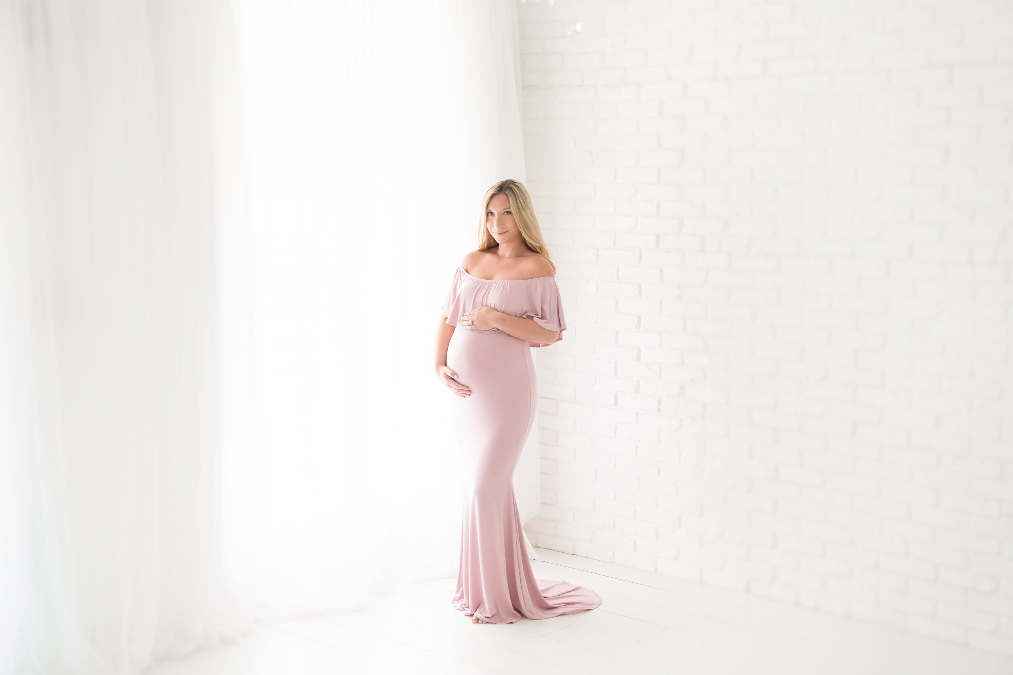 Maternity model wearing a lavander maxi dress in Jupiter Florida photography studio