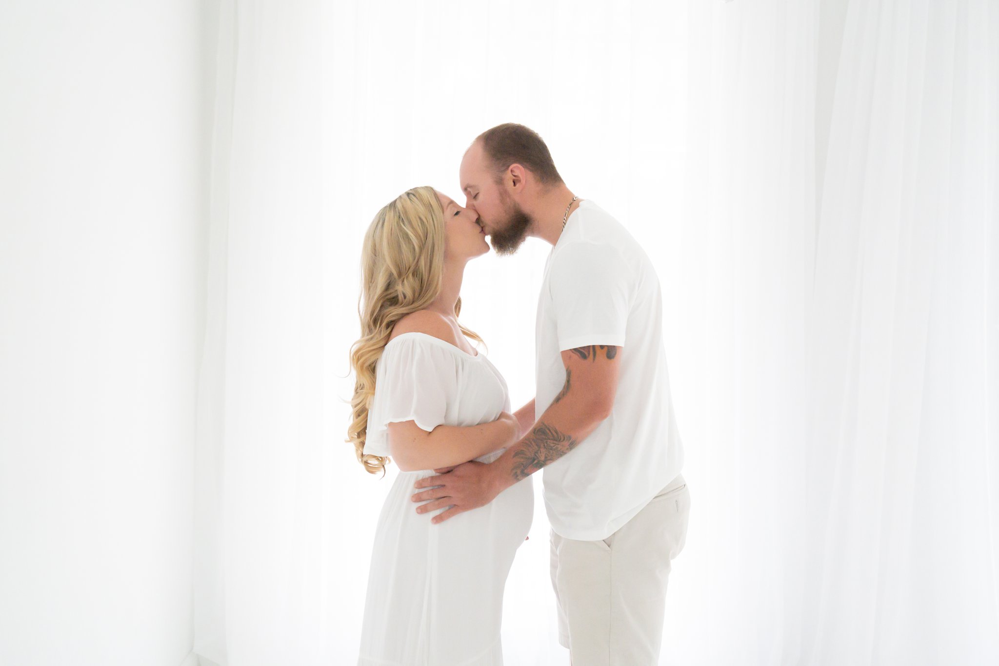 Expected mother with husband wearing a white studio maxi dress in Jupiter Florida photography studio