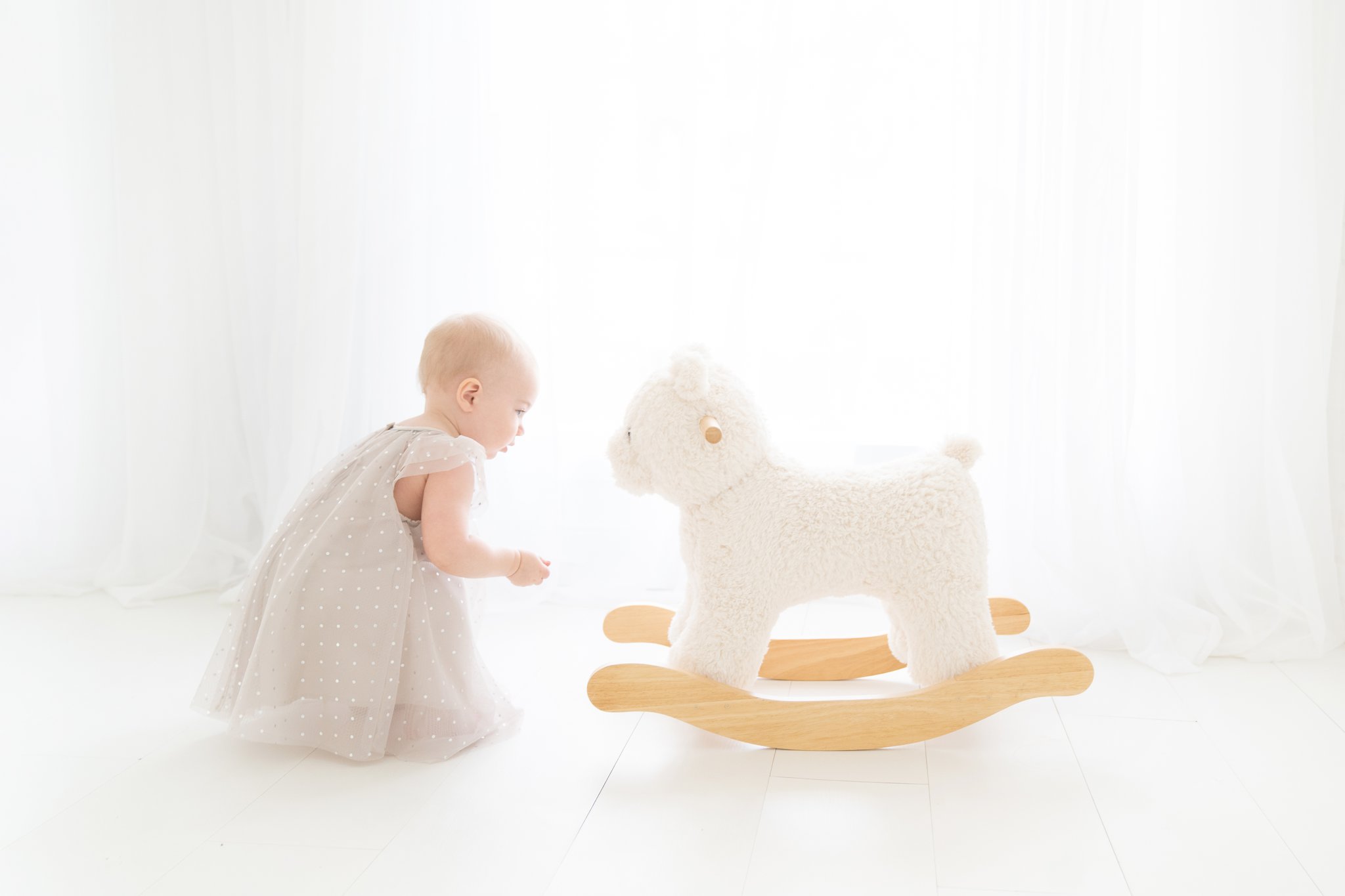 baby with a pottery Barn bear rocker in jupiter florida photography studio