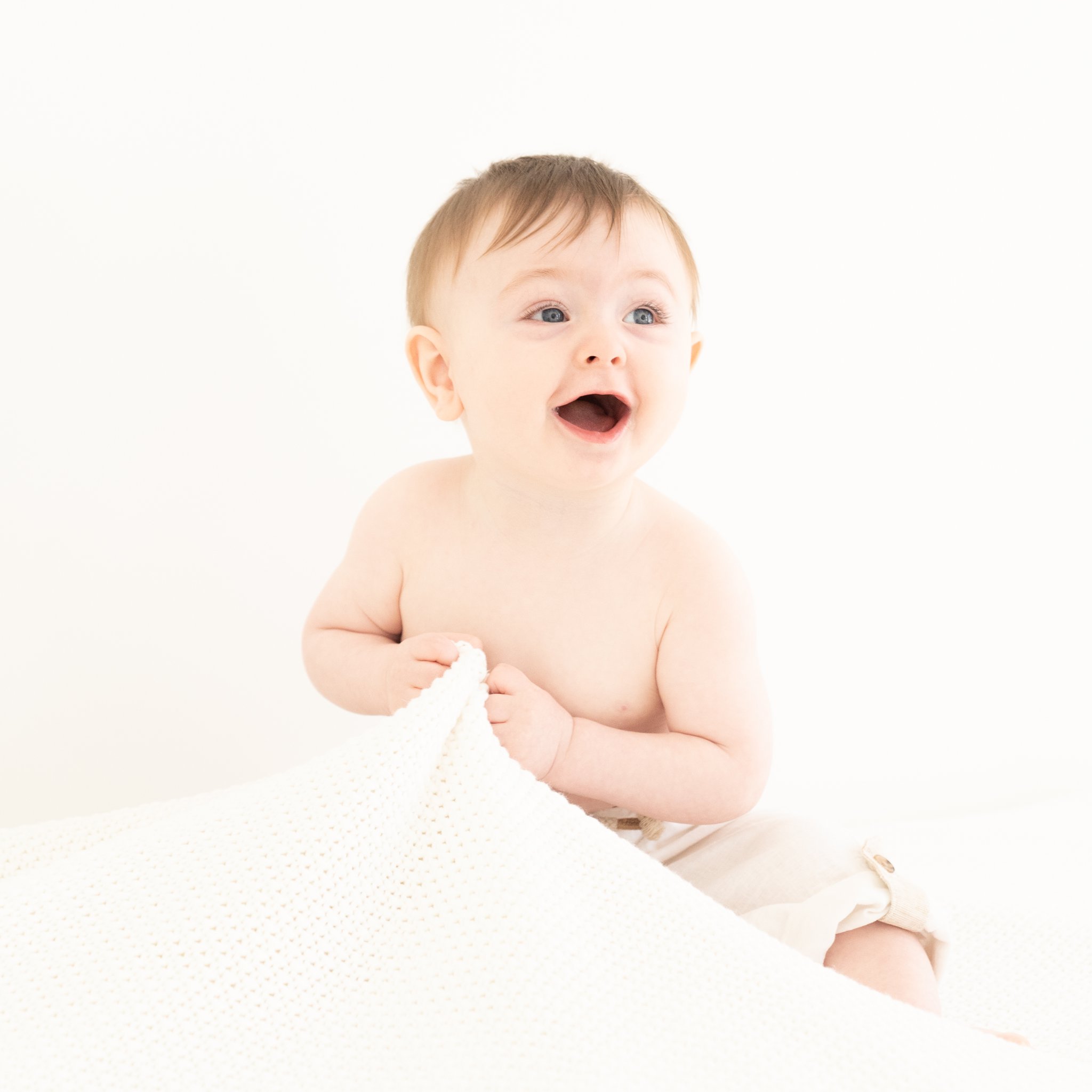 Baby boy sitting while having his pictures taken in a Jupiter Fl photography Studio