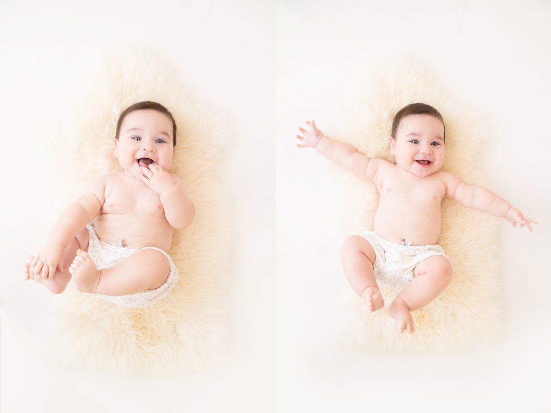  Photographer making baby smile while laying on his back on a fur rug