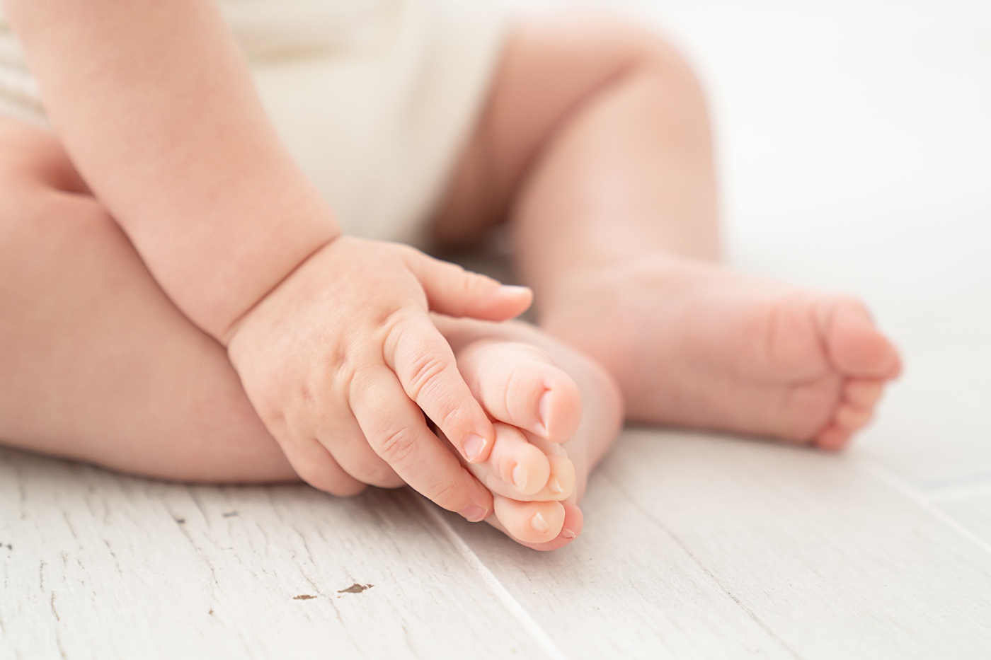Close up of a baby boy's feet and hand 