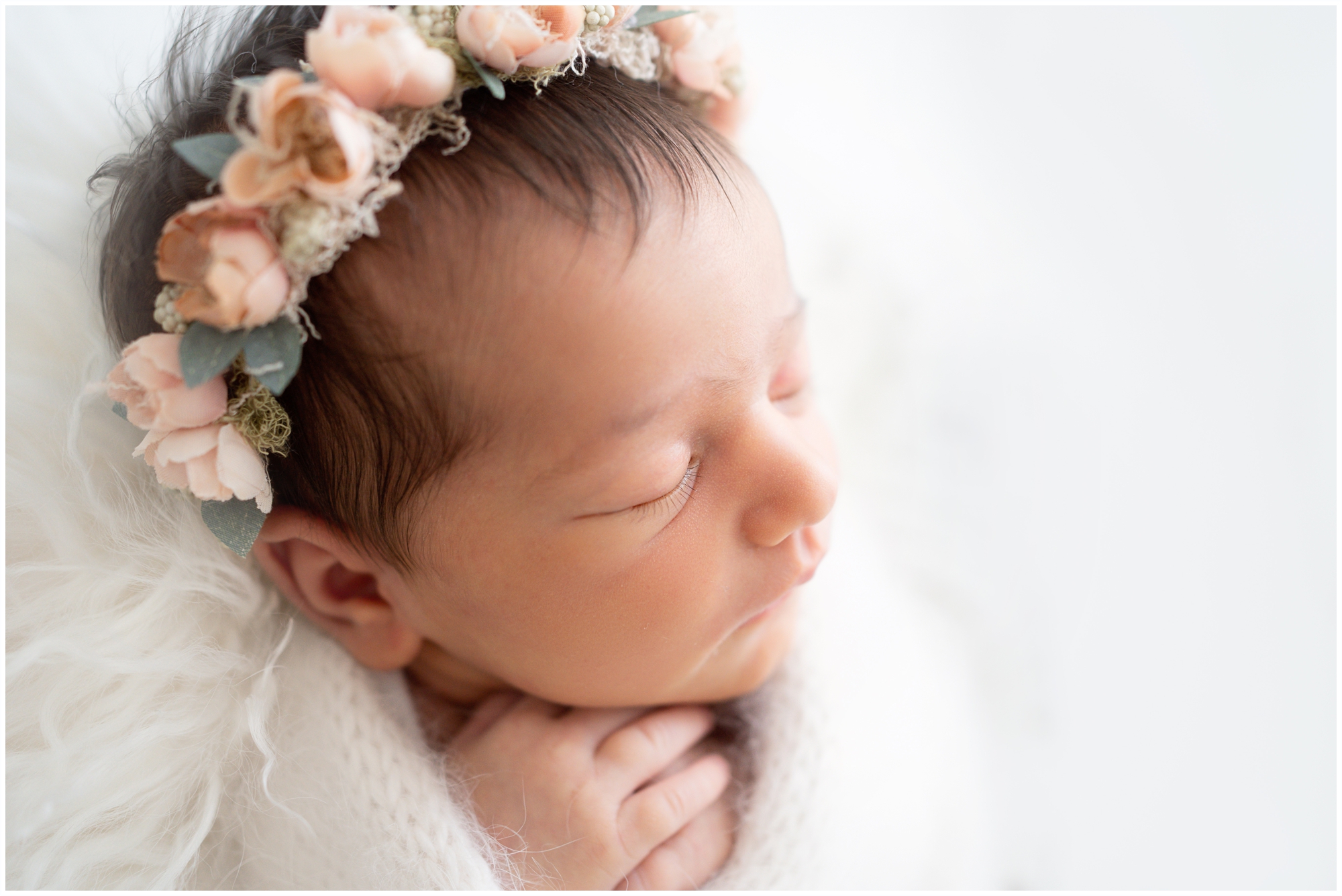 Brand new baby swaddled in white laying vintage bucket surrounded by pink flowers being photographed in Jupiter Fl studio